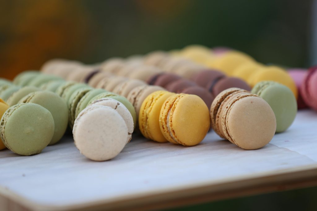 Close-up of vibrant French macarons arranged on a white surface, showcasing various flavors.