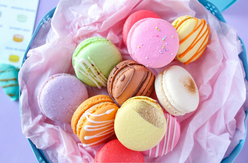 A vibrant mix of French macarons in a basket, perfect for dessert lovers.
